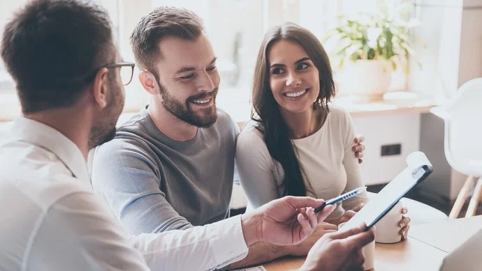 Ein Paar wird von einem Berater am Schreibtisch beraten