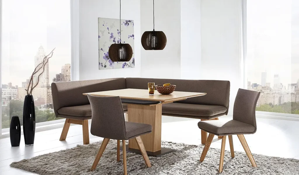 Wohnen - Esstisch aus Holz auf massiven Holzbein mit gepolsterten braunen Bank und zwei Stühlen auf Holzbeinen