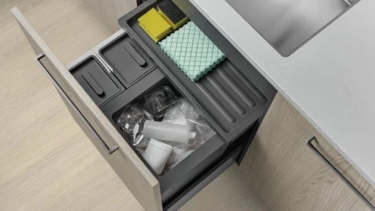 Abfallsammler in einer Schublade in einer Küche mit hellen Holzfronten