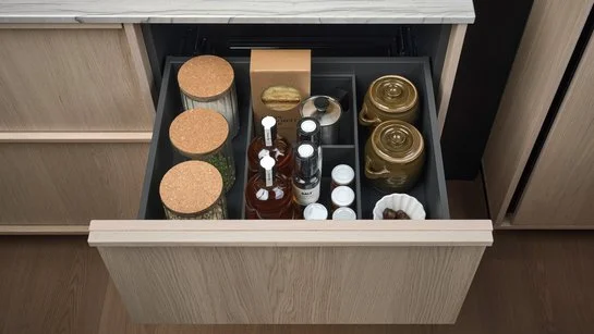 Offene Küchenschublade mit Inneneinteilung für Flaschen und Vorräten