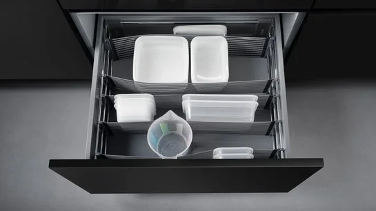 Offene Küchenschublade mit elastischen Bändern zur Trennung des Inhalts