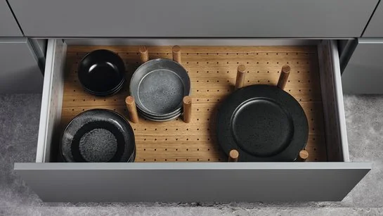 Offene Küchenschublade mit Innenausstattung aus Eiche mit Tellerhaltern