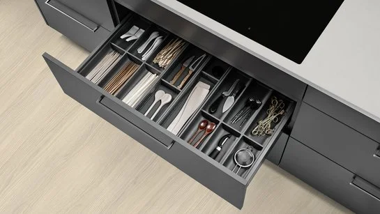 Besteckeinsatz in einer geöffneten Schublade in einer Kücheninsel