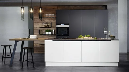 Weiße Inselküche mit angebautem Tisch mit Hockern, dahinter Hochschränke in anthrazit