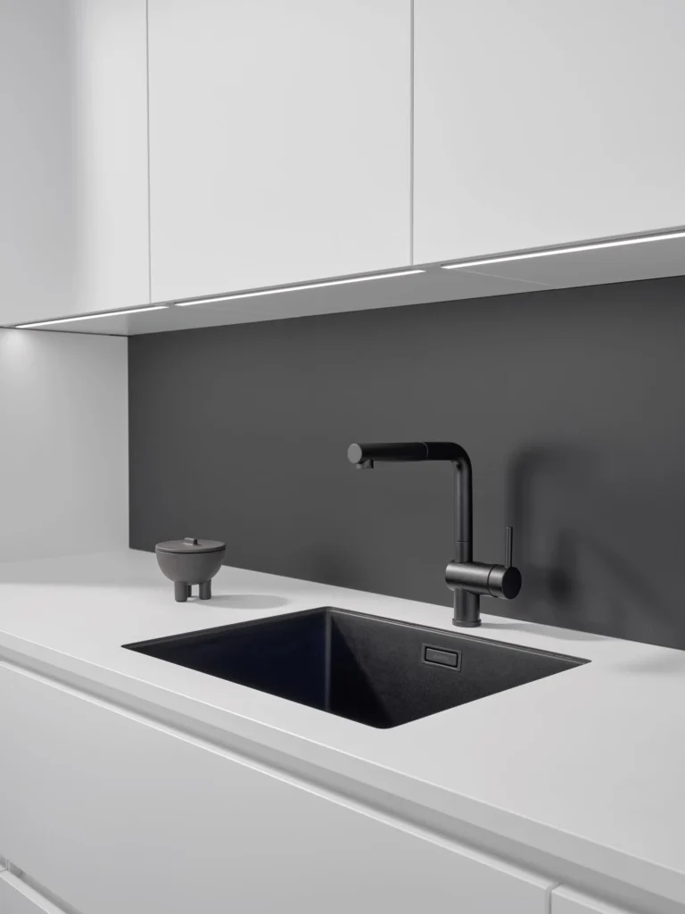 Moderne Küche mit schwarzem Waschbecken und weißen Schränken