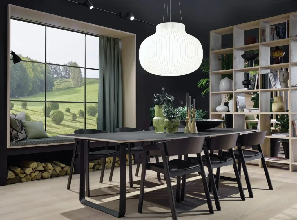 Großer dunkler Esstisch mit Stühlen vor Fenster