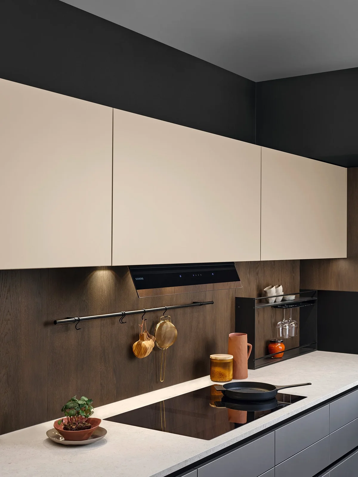 Graue Küchenzeile mit heller Arbeitsplatte und sandfarbenen Oberschränken