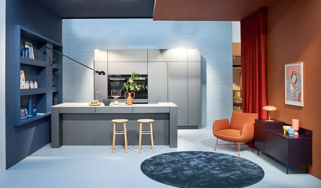 Moderne Küche mit grau-matten Paneelen und einer Arbeitsinsel in einem blau-orangefarbenen Interieur