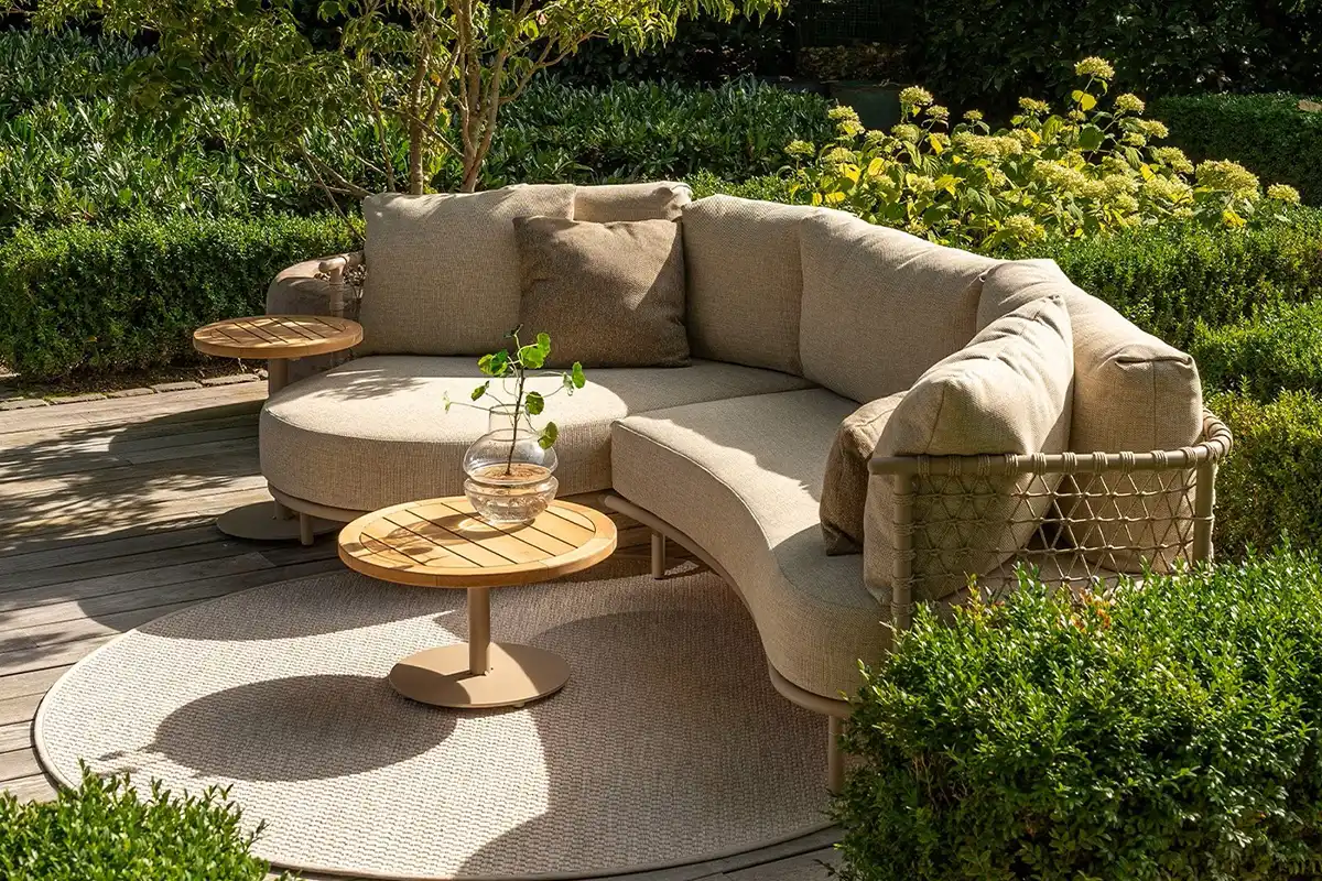Runder Tisch auf Holzdeck mit gemütlichem Sofa