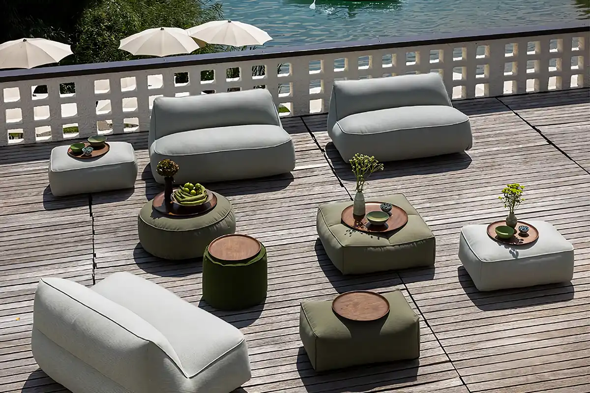 Weiche Gartenmöbel in Grün und Beige stehen auf einer Holzterrasse