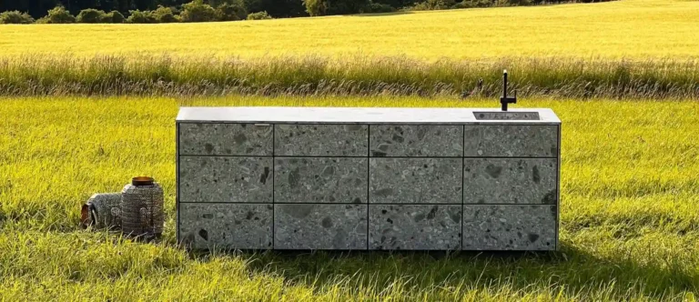 Eine Outdoor-Küche in Betonoptik steht auf einer Wiese
