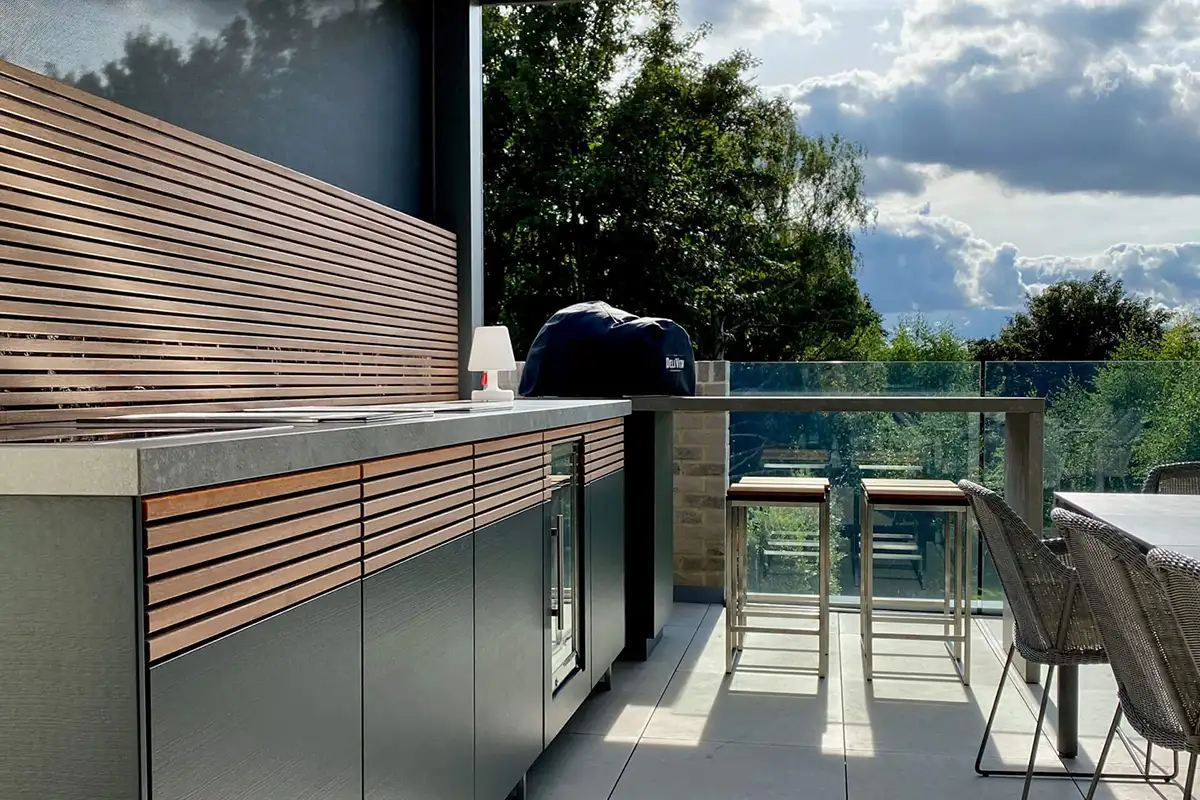 Eine Außenküche mit einem Tisch und Stühlen